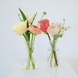 Bud vase sized spring flower arrangement set in a bud vase on a white pedestal and neutral background. Available for same day local delivery and pickup in Columbus Ohio 