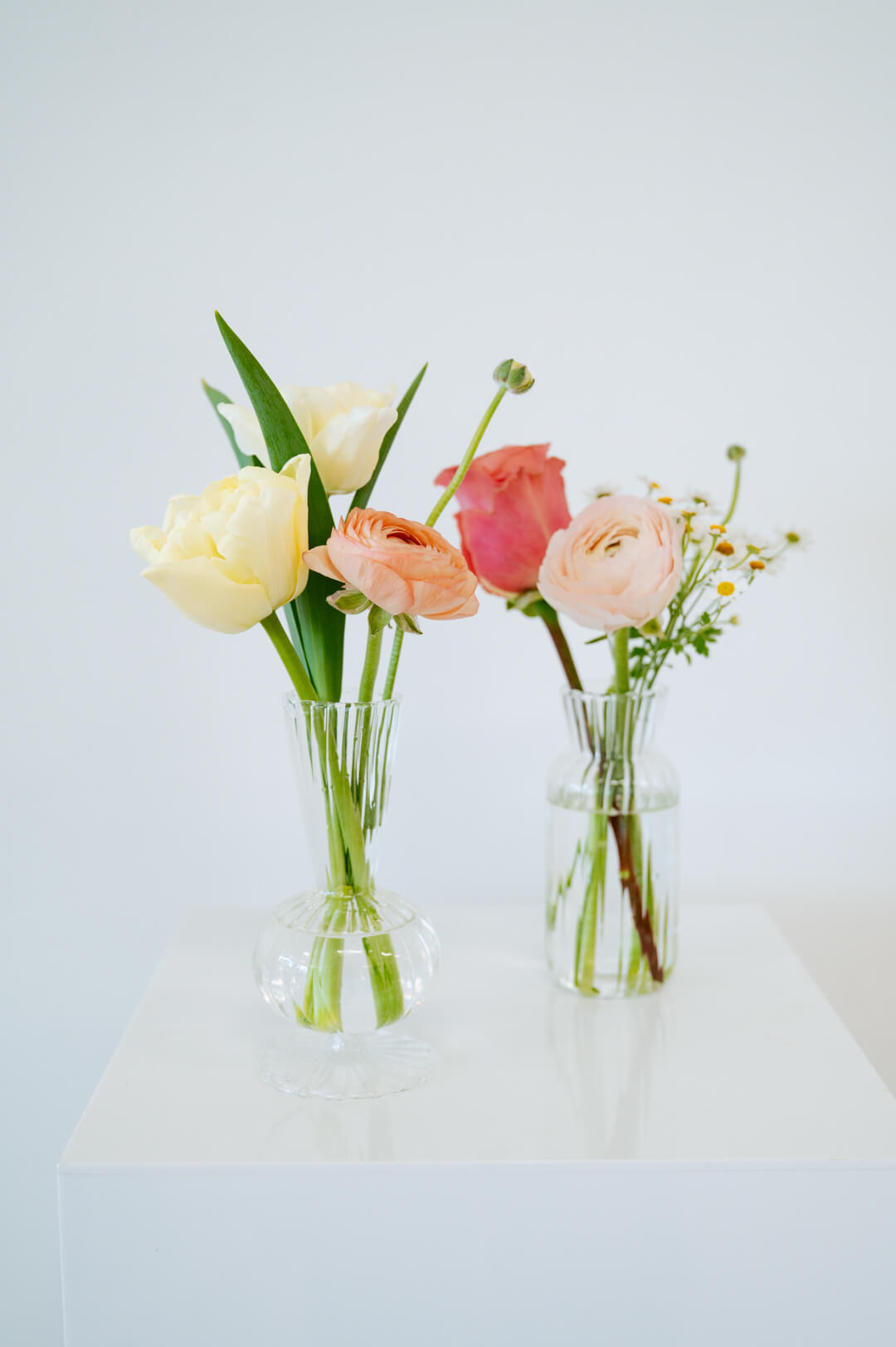 Bud vase sized spring flower arrangement set in a bud vase on a white pedestal and neutral background. Available for same day local delivery and pickup in Columbus Ohio 