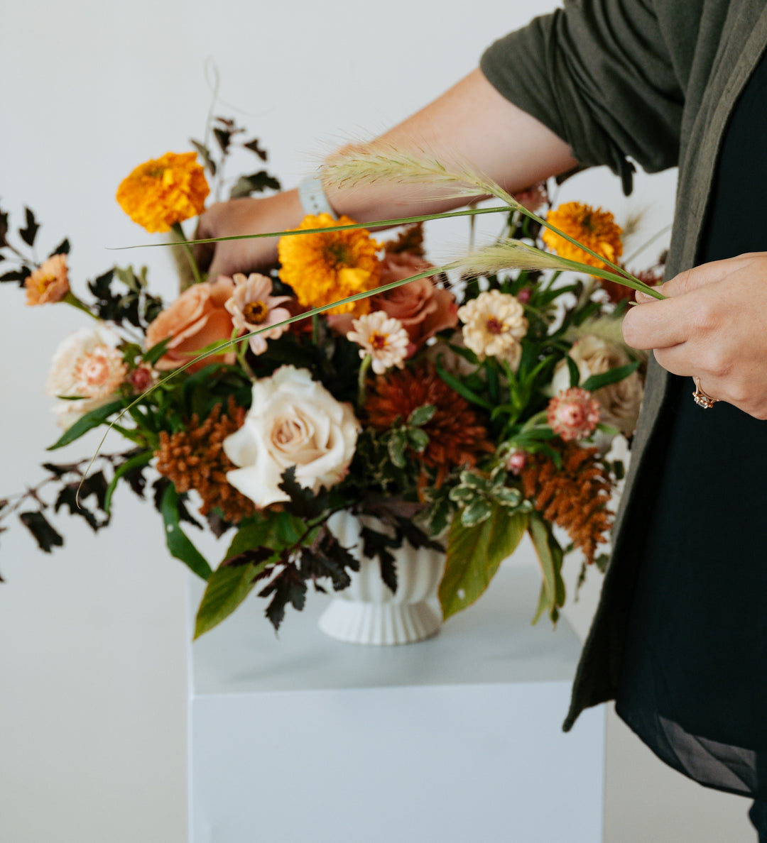 fall themed arrangement set on a white pedestal against a neutral backdrop for pick-up or delivery in central, ohio