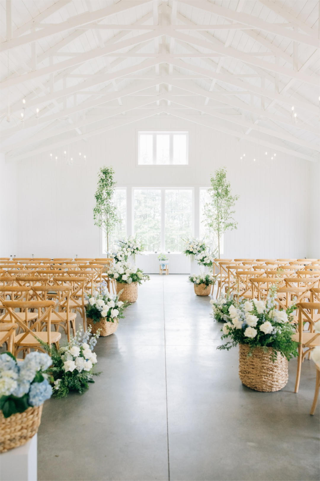 A Columbus wedding ceremony featuring white walls, white flowers and wooden chairs, creating a charming and elegant atmosphere.