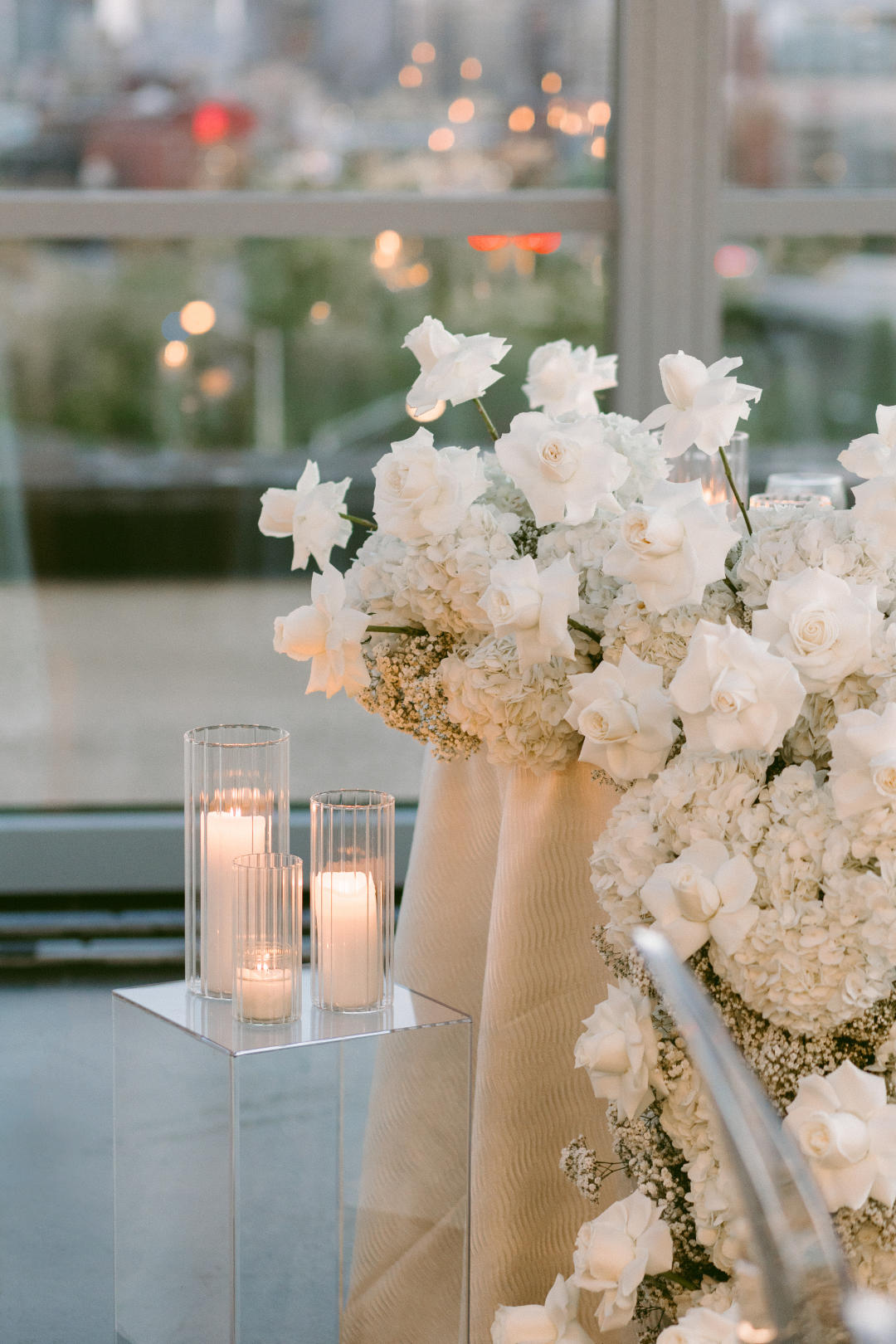 Elegant white wedding table featuring candles and floral arrangements, designed by Flocal Co wedding florist.