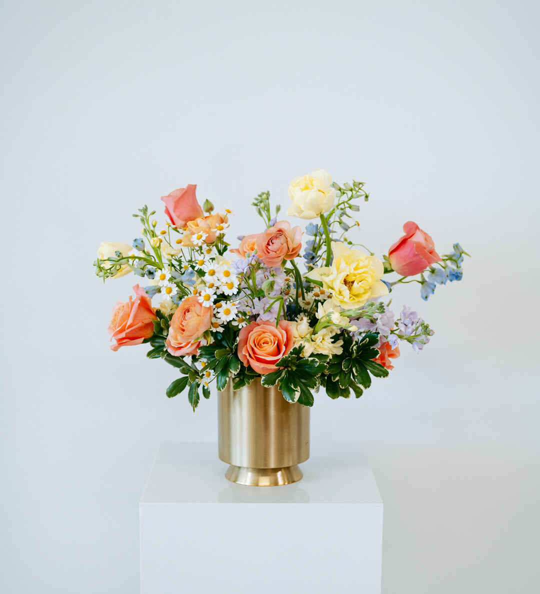 Large april showers arrangement showcasing spring florals set in a gold vase on top of a white pedestal- available for same day pick-up or local delivery in Columbus, Ohio