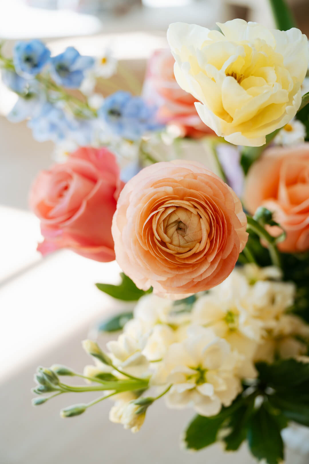 Luxe Grand sized spring flower arrangement set in a white vase on a white pedestal and neutral background. Available for same-day local delivery and pickup in Columbus Ohio 