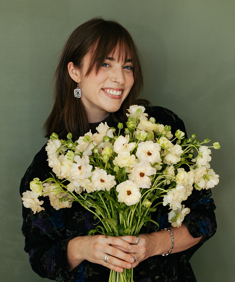 Woman holding a bouquet of white flowers against a green background