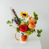Colorful bouquet of flowers in a mug that reads Worlds Best Teacher available for local pickup and delivery in Columbus Ohio for teacher appreciation gifting