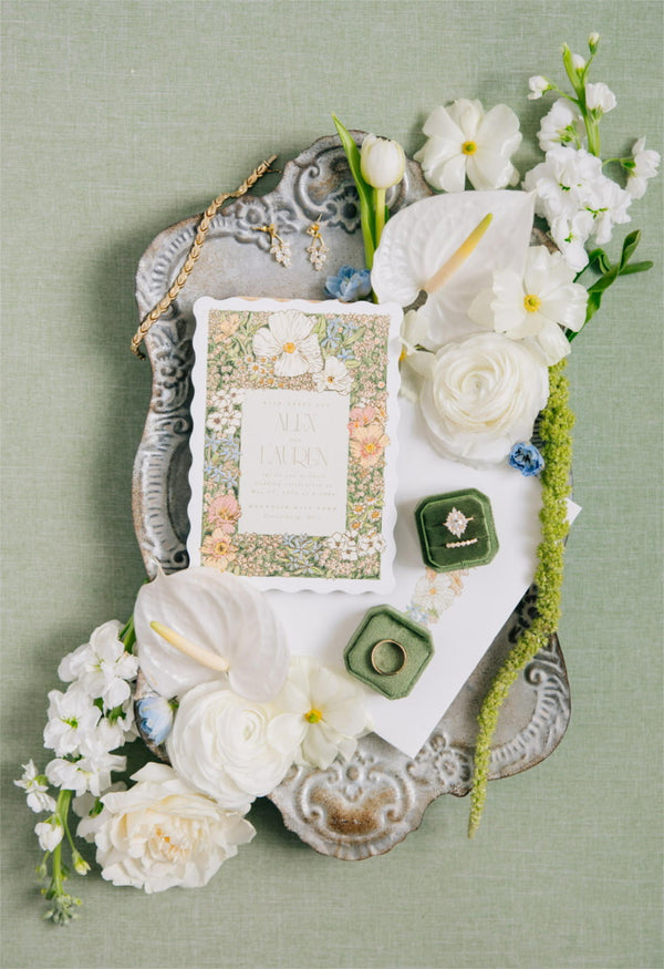 Wedding stationery for a Columbus wedding with wavy edges laid on an aged silver platter and flowers surrounding it.