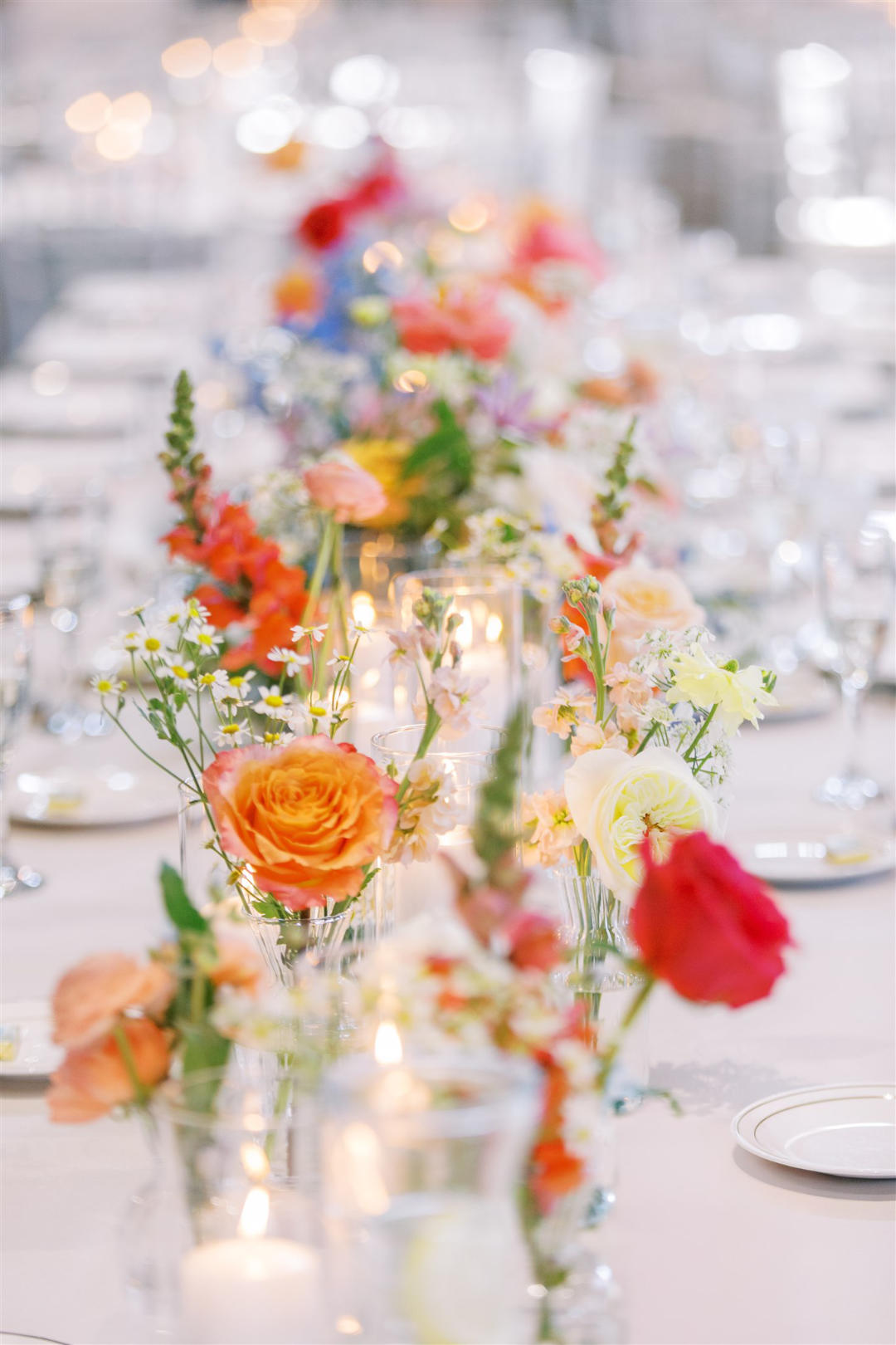 A long table decorated with elegant white and blue flowers and soft candlelight, perfect for a special gathering.