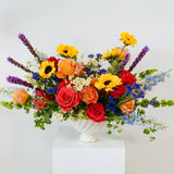 Colorful flower arrangement in a white vase on a white background