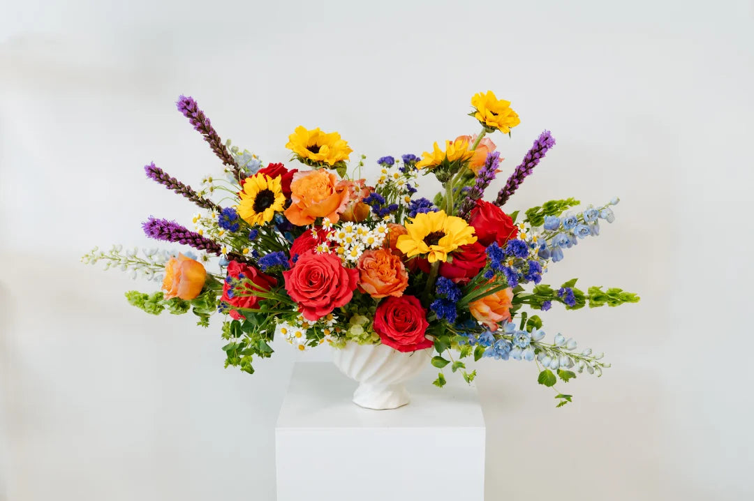 Colorful flower arrangement in a white vase on a white background