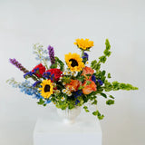 Colorful flower arrangement in a white vase on a white background