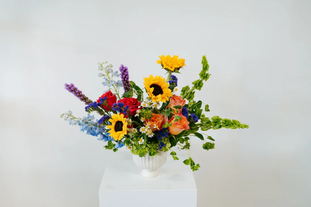 Colorful flower arrangement in a white vase on a white background