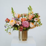 Large sized spring flower arrangement set in a gold vase on a white pedestal and neutral background. Available for same day local delivery and pickup in Columbus Ohio 