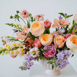 Luxe Grand sized spring flower arrangement set in a white vase on a white pedestal and neutral background. Available for same day local delivery and pickup in Columbus Ohio 