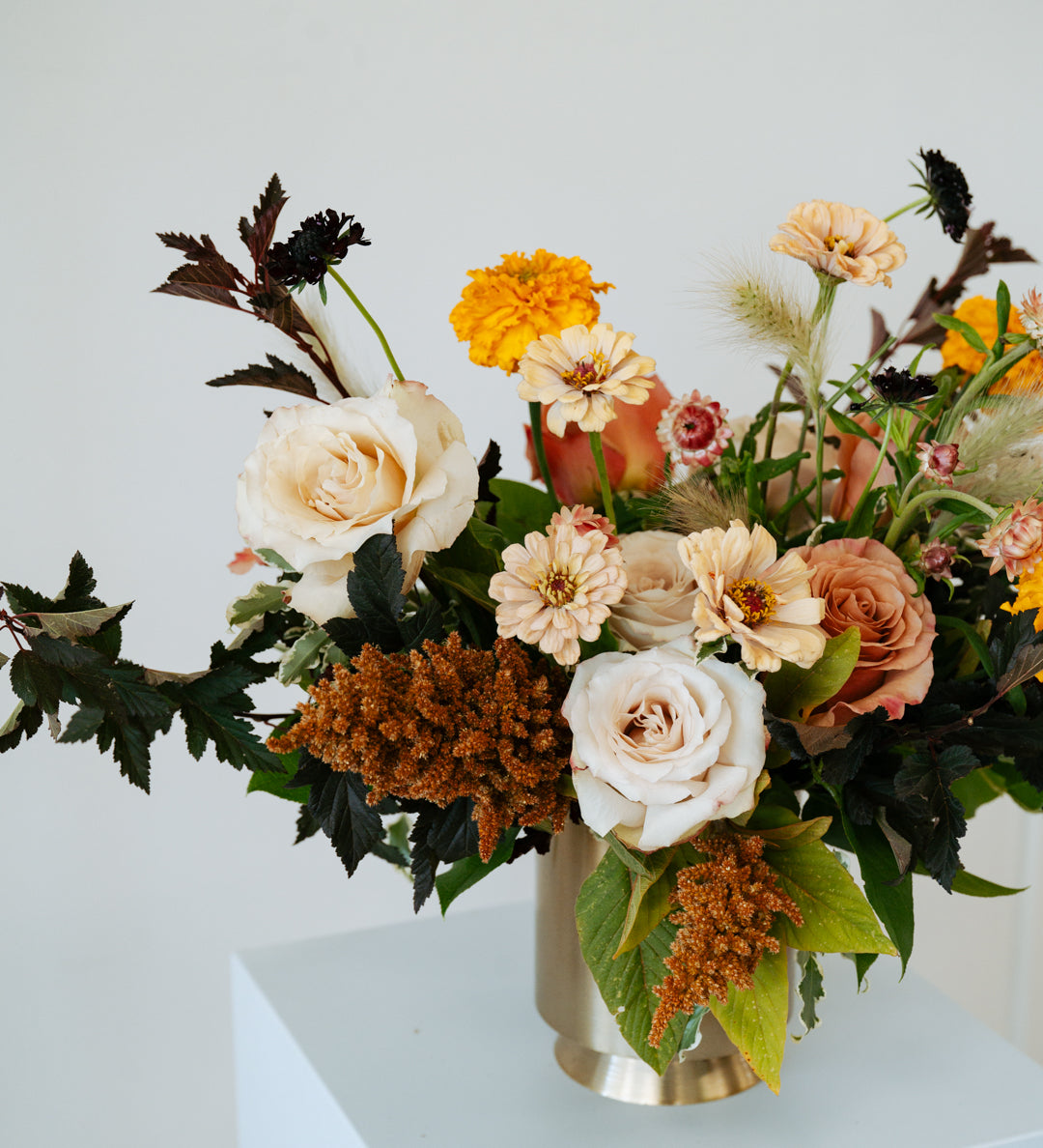 Floral arrangement in a vase on a white pedestal against a light gray background available for pickup and delivery in Central, Ohio