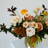 Floral arrangement in a vase on a white pedestal against a light gray background available for pickup and delivery in Central, Ohio