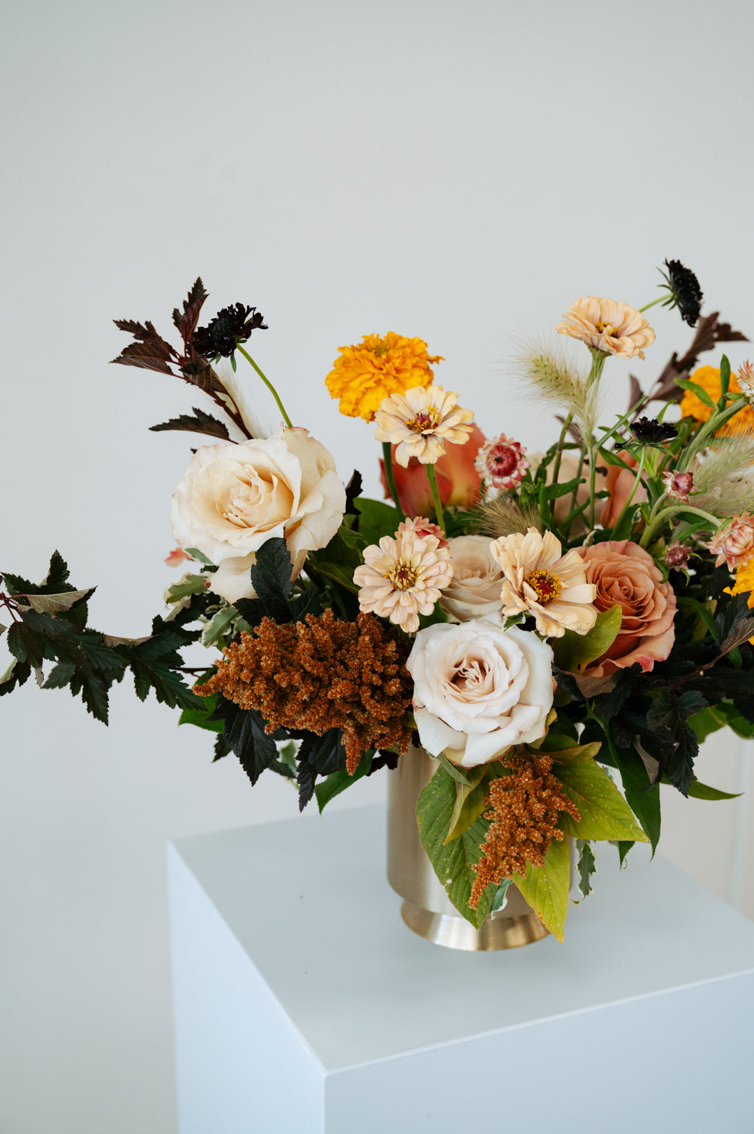 Floral arrangement in a vase on a white pedestal against a light gray background available for pickup and delivery in Central, Ohio