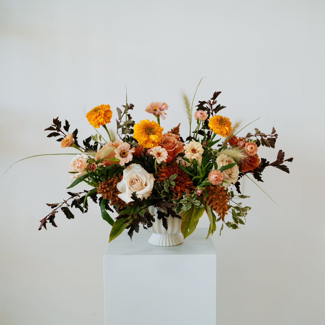 Floral arrangement with autumn colors in a white vase on a light gray  background available for pick-up and delivery in Central, Ohio