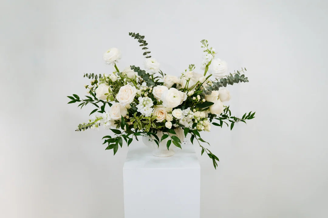 Luxe floral arrangement in a white vase on a light gray background