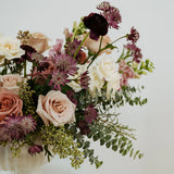 Columbus Ohio floral arrangement with pink, purple, and white flowers in a white vase on a light background