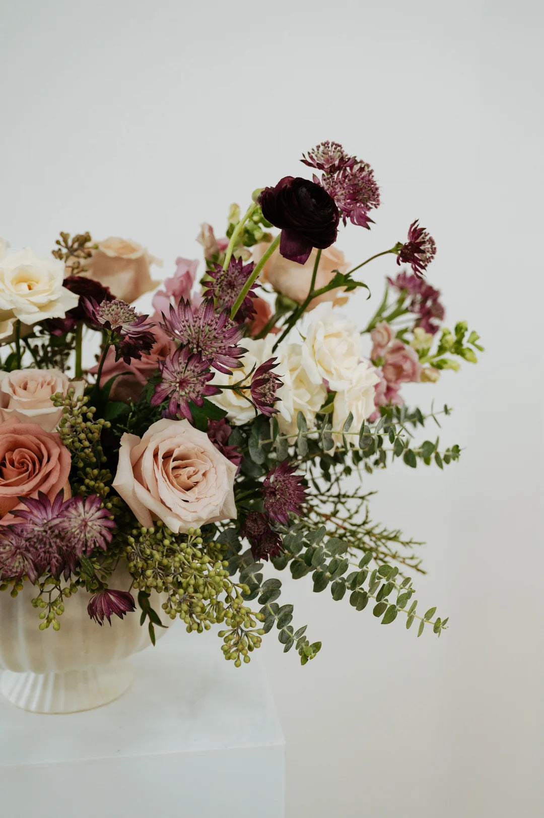 Columbus Ohio floral arrangement with pink, purple, and white flowers in a white vase on a light background