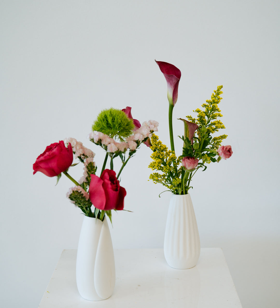 Bud Vase flower arrangement set in a white vase on a white pedestal and neutral background. Available for same day local delivery and pickup in Columbus Ohio 