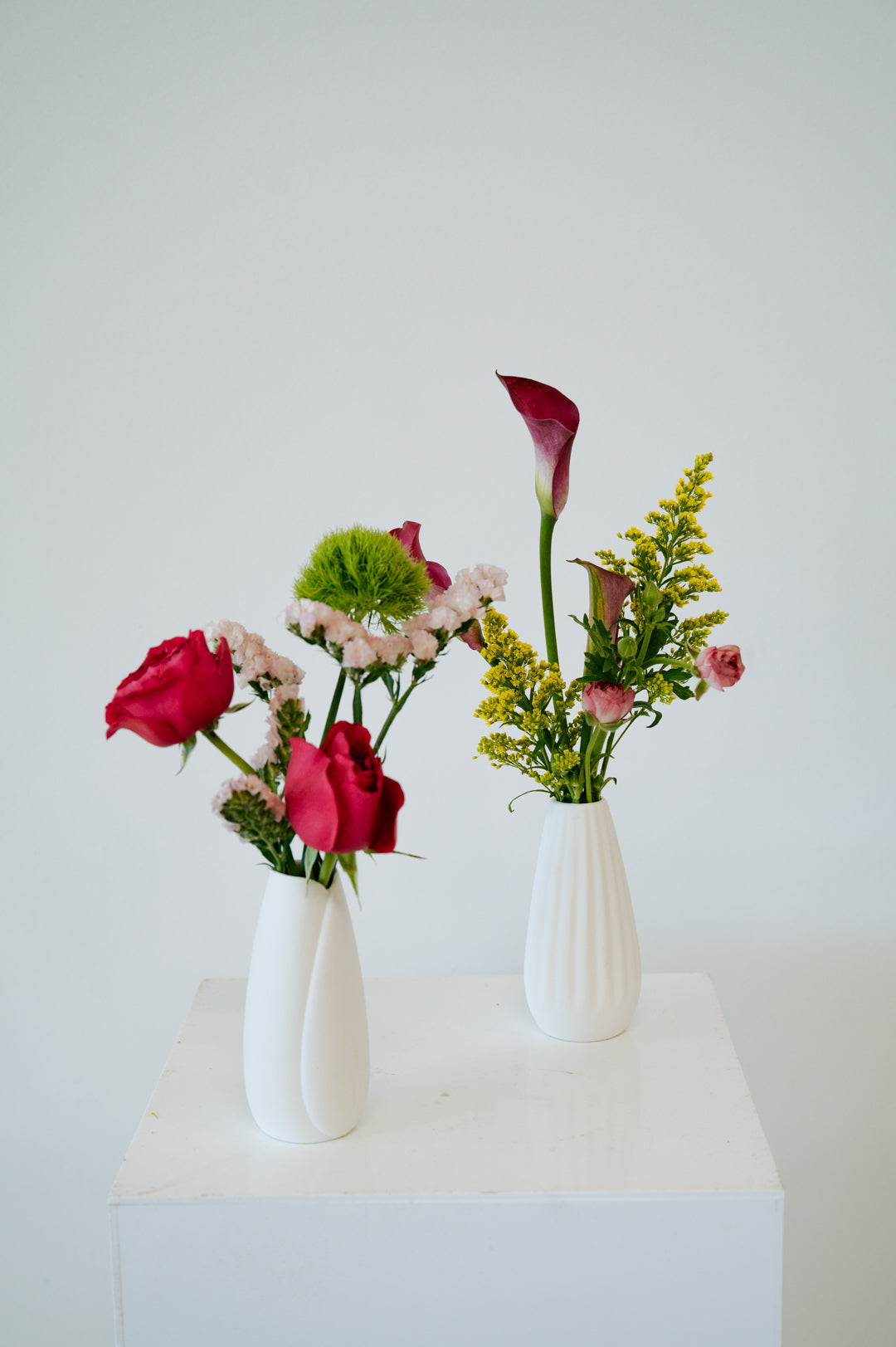 Bud Vase flower arrangement set in a white vase on a white pedestal and neutral background. Available for same day local delivery and pickup in Columbus Ohio 