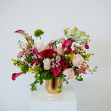 Large statement sized spring flower arrangement set in a gold vase on a white pedestal and neutral background. Available for same day local delivery and pickup in Columbus Ohio 