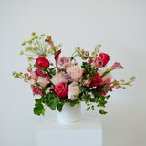 Petite sized spring flower arrangement set in a white vase on a white pedestal and neutral background. Available for same day local delivery and pickup in Columbus Ohio 